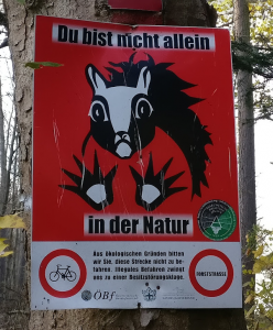 Sign with a scary looking squirrel: You are not alone in nature. For ecological reasons we ask you. not to drive this route. Illegal driving compels us to a suit of property felony (as rendered by Google Translate).